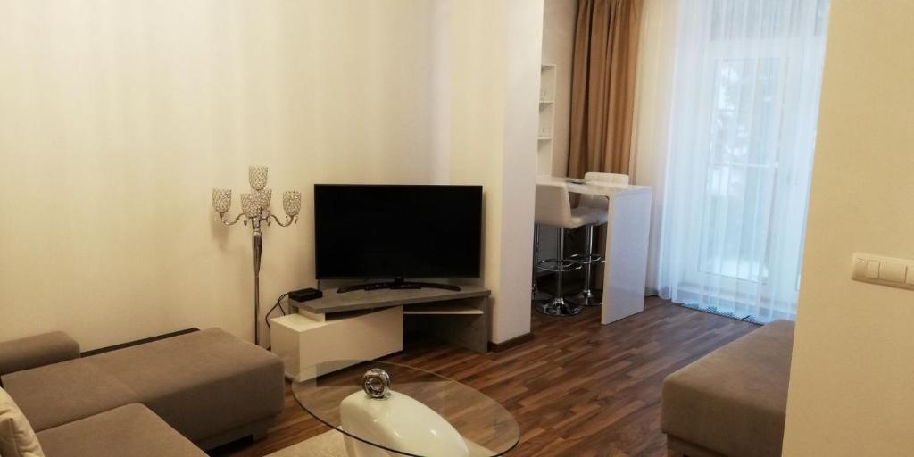 a living room with a couch and a flat screen tv at Oliver apartmán 6 in Štrbské Pleso