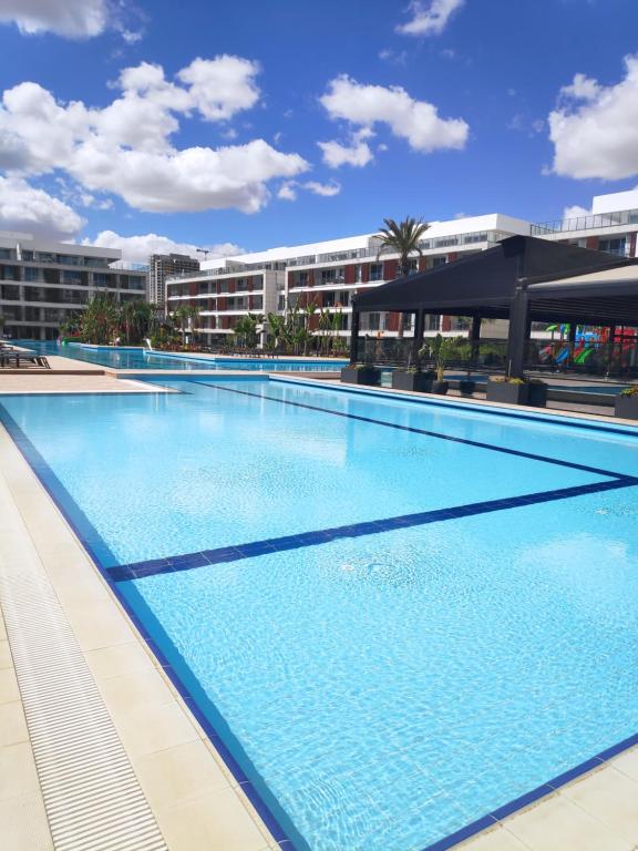 een groot zwembad voor een gebouw bij RELAX&DREAM apartment Long Beach in Saint Yeorgios
