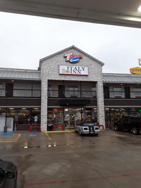 a car parked in a parking lot in front of an army mall at Italy Inn in Italy