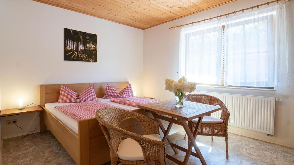 Schlafzimmer mit einem Bett, einem Tisch und Stühlen in der Unterkunft Springhansenhof in Oppenau