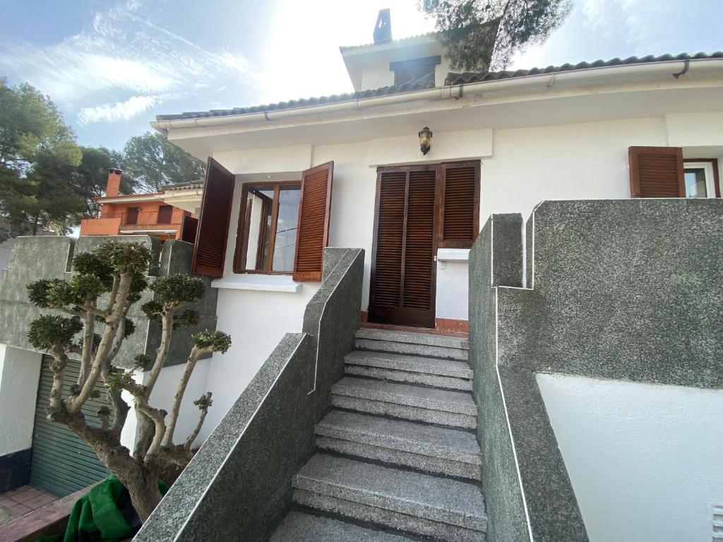 a house with stairs leading up to a door at Chalet cerca a la playa con jardín y barbacoa in Tarragona