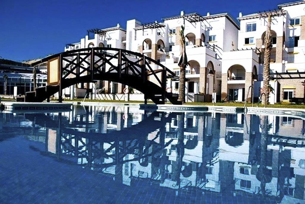 uma piscina de água com uma ponte em frente a um edifício em Al-Andalus Thalassa Home Star em Vera