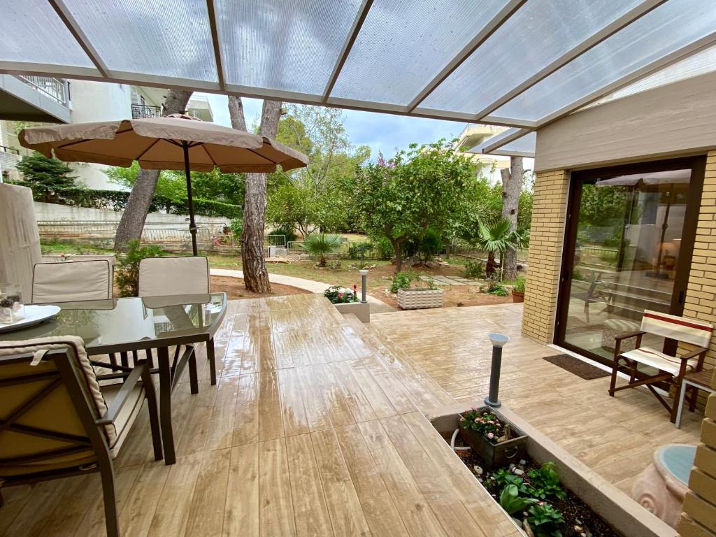 een patio met een tafel en een parasol bij Amazing Garden House in Athene