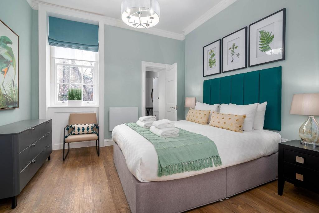 een slaapkamer met een groot bed en een stoel bij 37 Doughty Street in Londen