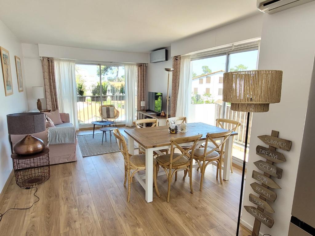 uma sala de estar com uma mesa de jantar e cadeiras em Havre de paix 4 étoiles, à 100 mètres de la plage em Saint-Georges-de-Didonne