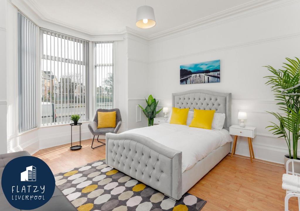 - une chambre blanche avec un lit et des oreillers jaunes dans l'établissement FLATZY - 6 bed Oasis Close to Football Stadiums, à Liverpool