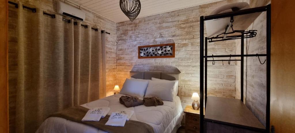 ein Schlafzimmer mit einem Bett mit zwei Handtüchern darauf in der Unterkunft Chalés Bella in Monte Verde