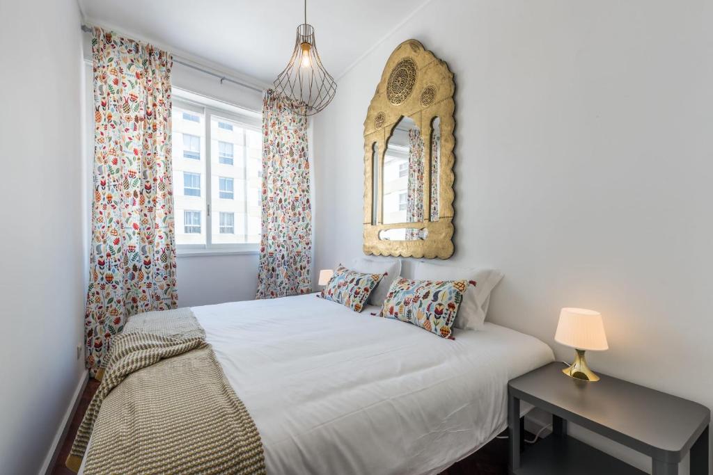 a bedroom with a bed and a table and a mirror at GuestReady - The Happy Place in Porto in Porto