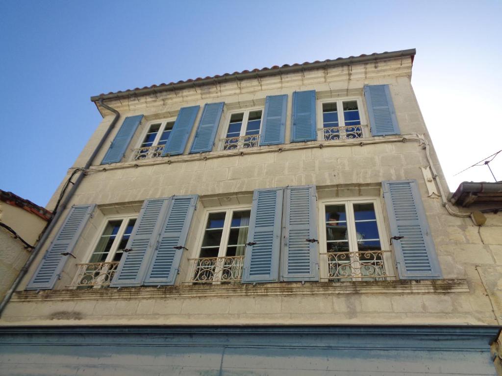 a building with blue shutters and windows on it at Maison Saint Jacques in Aubeterre-sur-Dronne