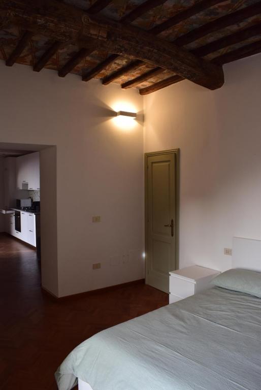 a bedroom with a white bed and a green door at Appartamento Ansidei 3 in Perugia