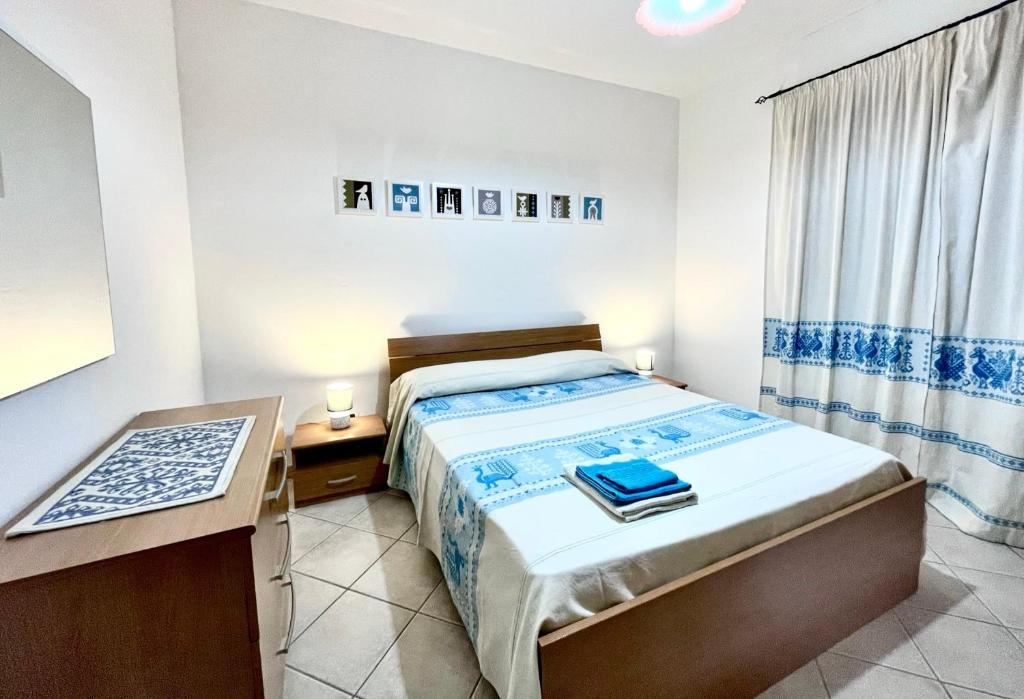 a small bedroom with a bed and a desk at Appartamento Centrale in Olbia
