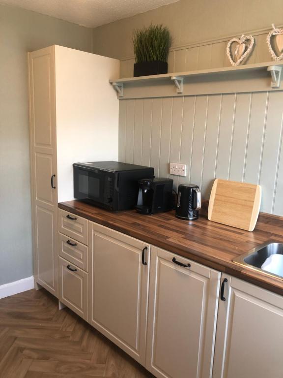 a kitchen with a counter with a microwave on it at Cranwell Court Apartments in Aberystwyth