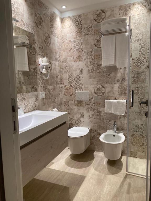a bathroom with a tub and a toilet and a sink at EUROPA Hotel in Vasto