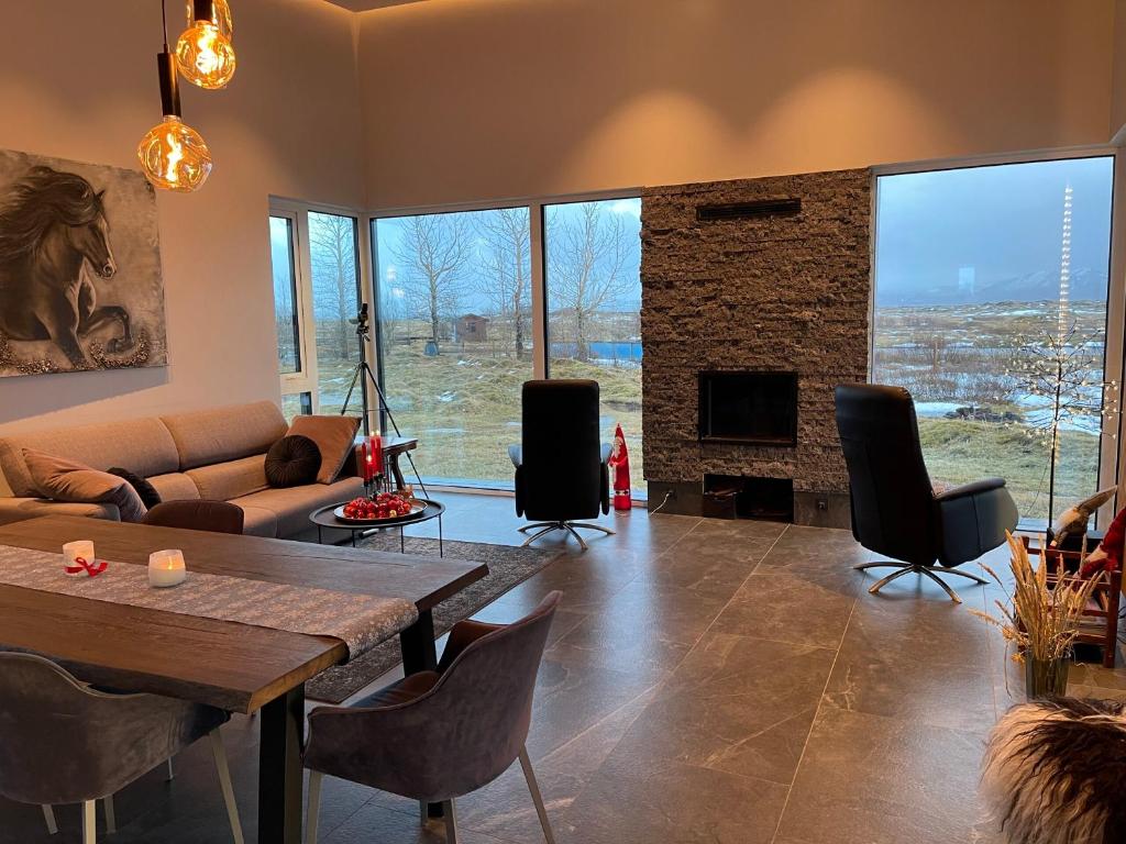 a living room with a table and a fireplace at Fögruvellir Country House in Hella