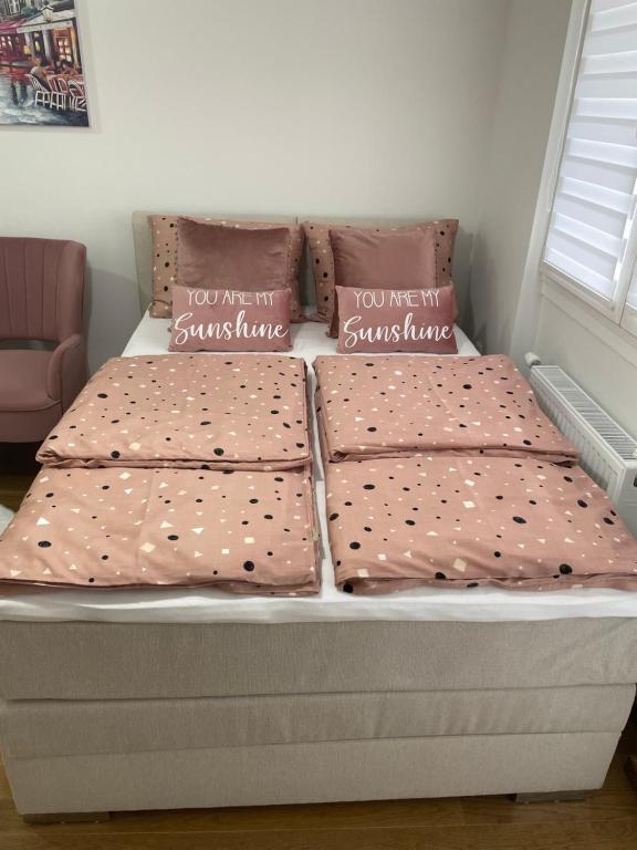 uma cama com dois lençóis e almofadas em Spring deluxe em Novi Sad