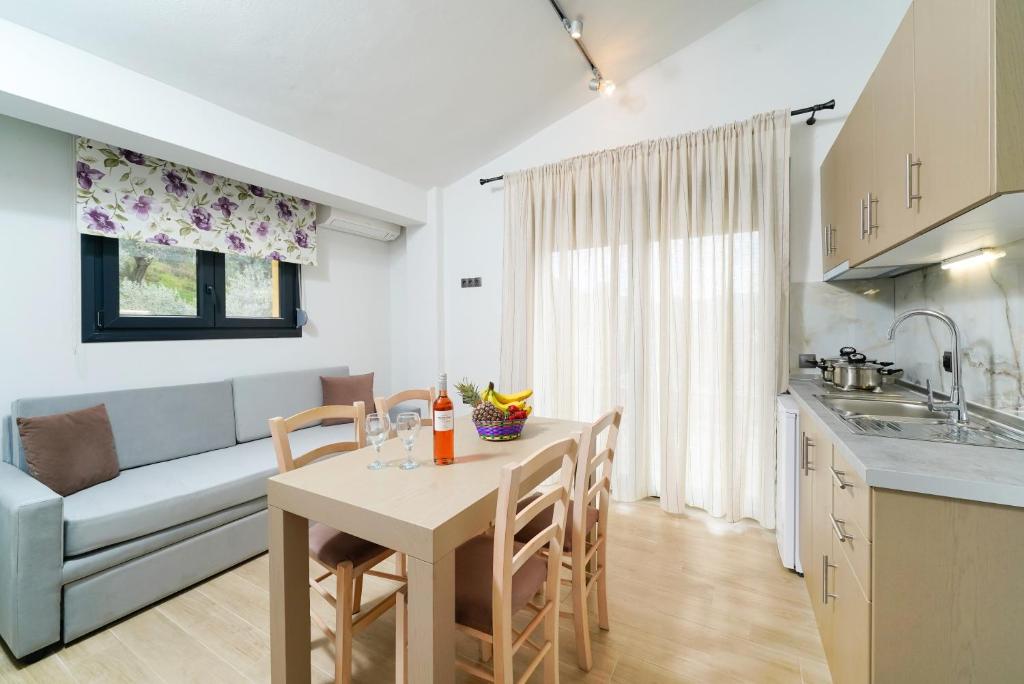 a kitchen and living room with a table and a couch at Serenity Apartments in Skala Potamias