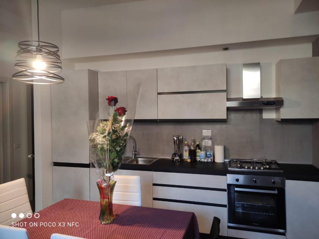 a kitchen with a table with a vase of flowers on it at Ricky-Lerua casa vacanze in Florence
