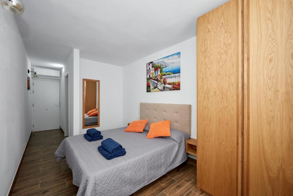 sypialnia z łóżkiem z dwoma niebieskimi ręcznikami w obiekcie El Patio Hostal w Alicante