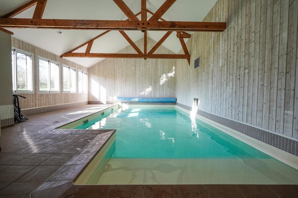 a swimming pool with a person standing in the water at Chambres d'hôtes La Roche in Saint-Hilaire-des-Landes