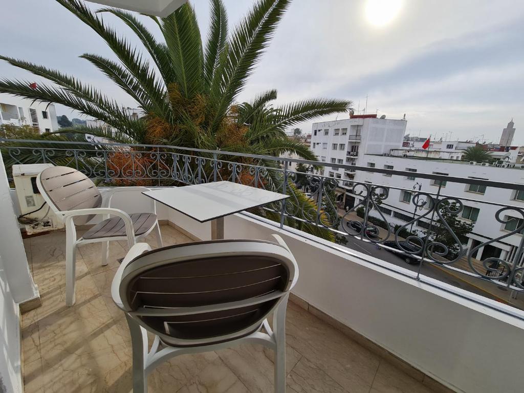 - Balcón con mesa y sillas en un edificio en Figuig Appart'Hotel, en Rabat