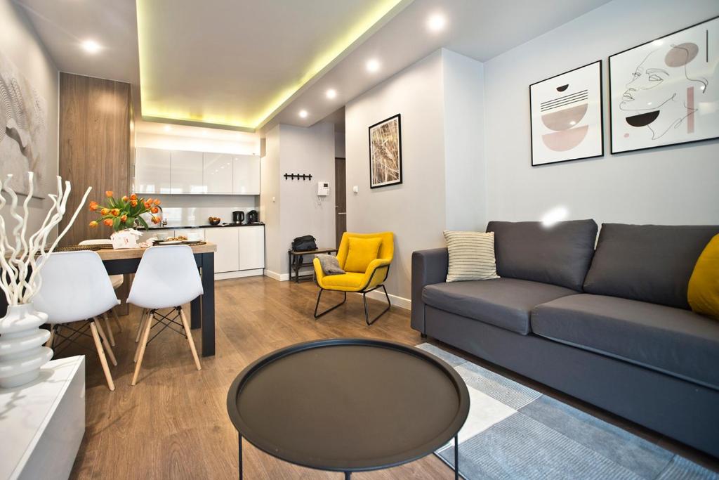a living room with a couch and a table at Browary Warszawskie P&O Serviced Apartments in Warsaw