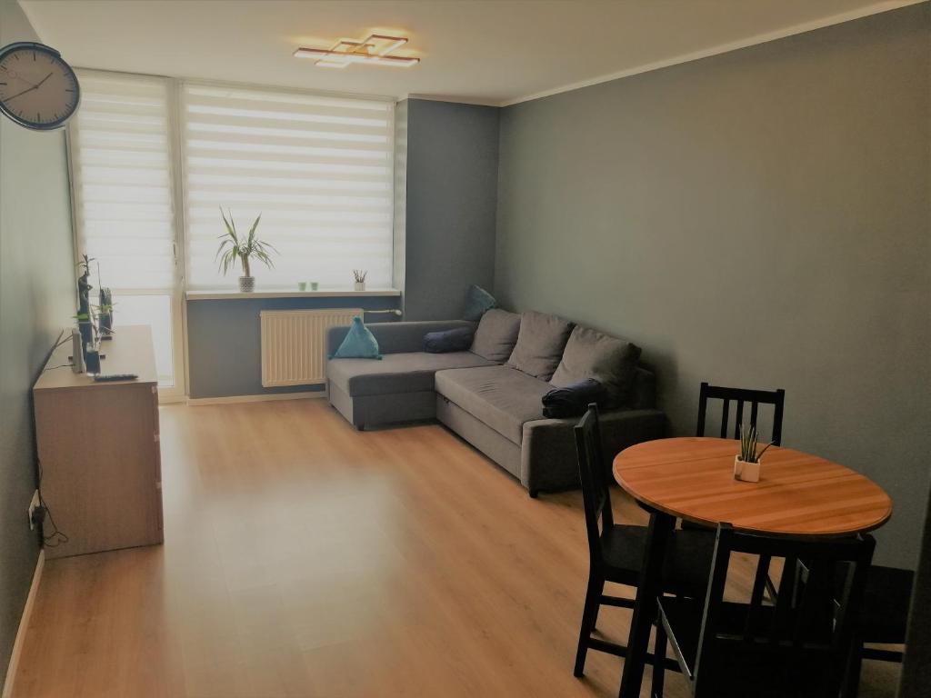 een woonkamer met een bank en een tafel bij Nadmorski Zojka-Apartament Gdańsk in Gdańsk