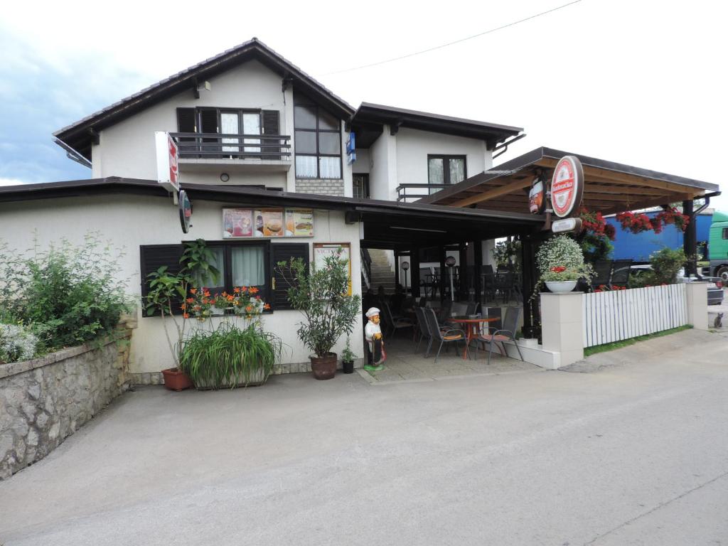 a white building with a restaurant on the street at Bed and Breakfast Victoria in Ogulin