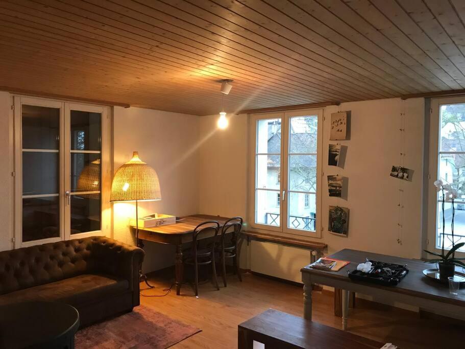 een woonkamer met een bank en een tafel bij Simple flat in the centre of Burgdorf - 72 m2 with private parking in Burgdorf