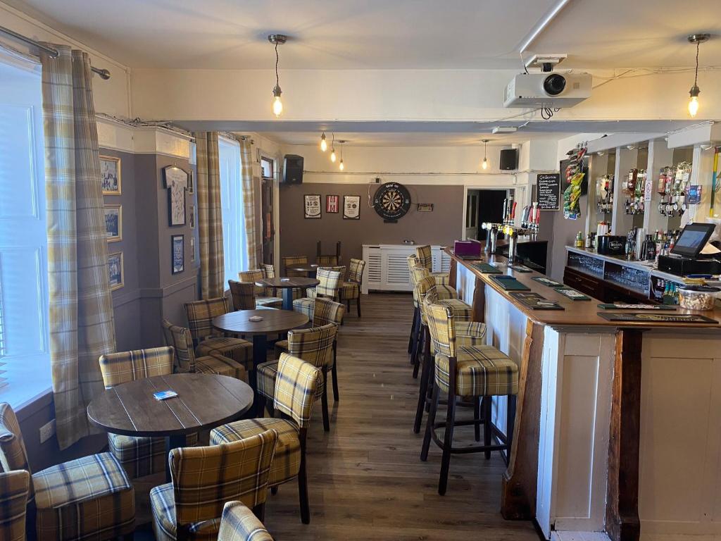 a bar in a restaurant with tables and chairs at Queensberry arms hotel in Kirkconnel