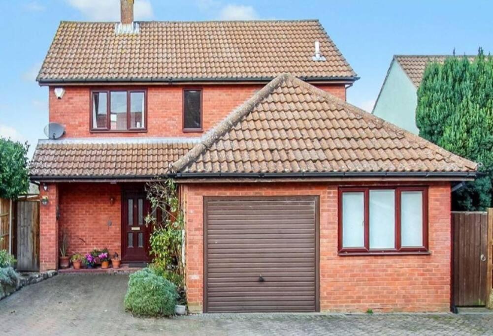 a red brick house with a garage at Famous White Horse on the hill in Westbury