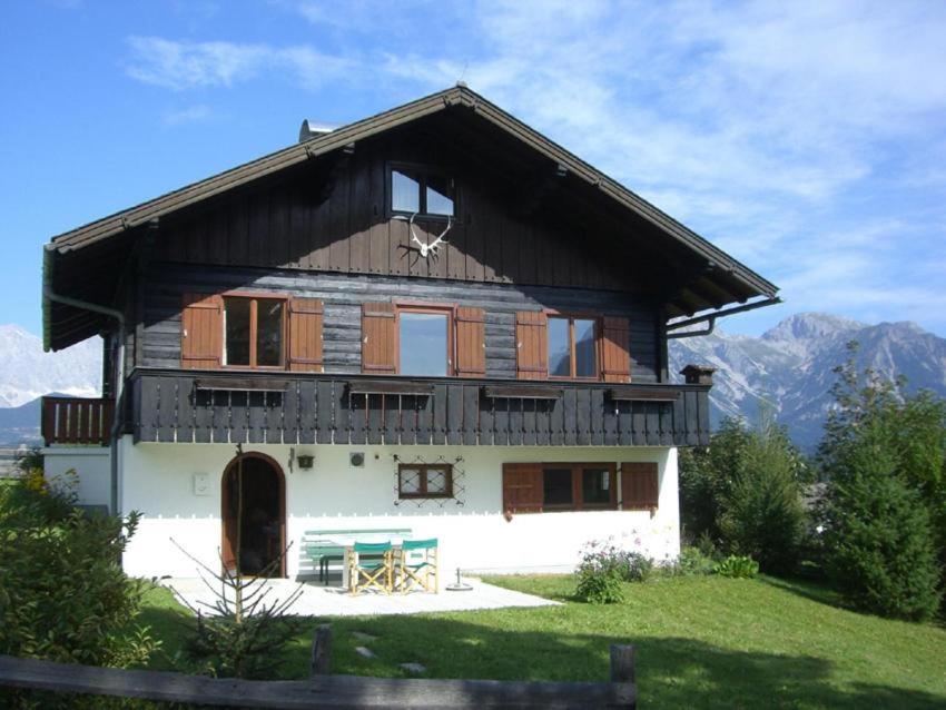 ein großes Holzhaus mit Bergen im Hintergrund in der Unterkunft CHALET MARESI in Schladming