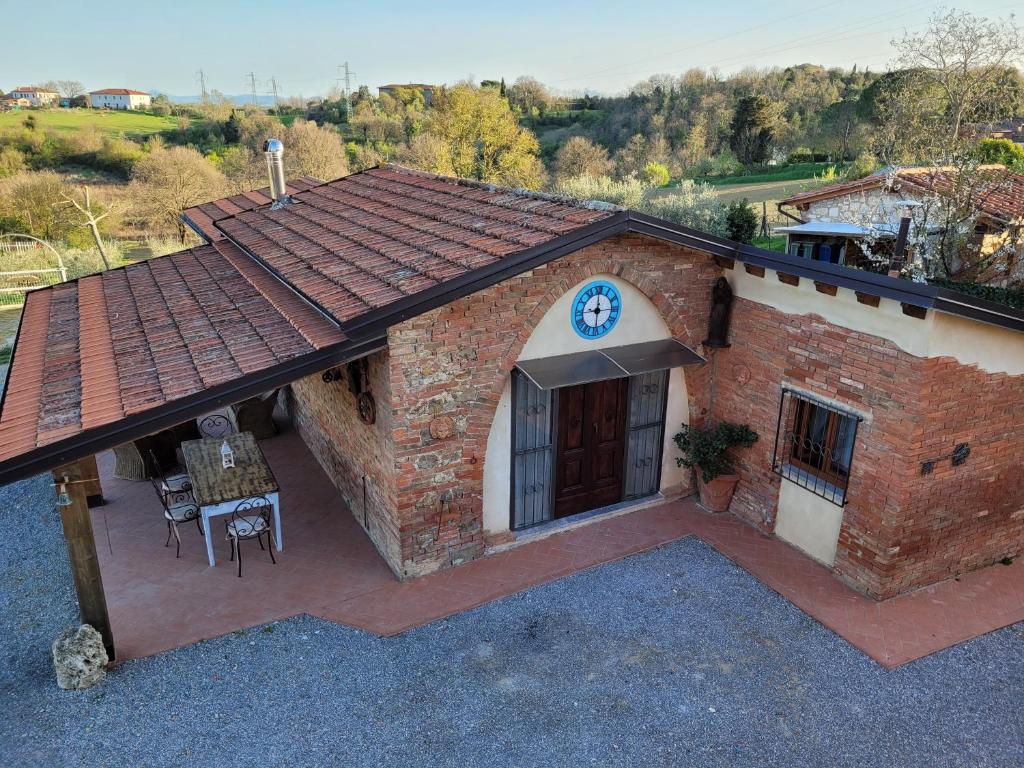 a brick building with a roof with a patio at Il Casale di Lucullo in Lucignano