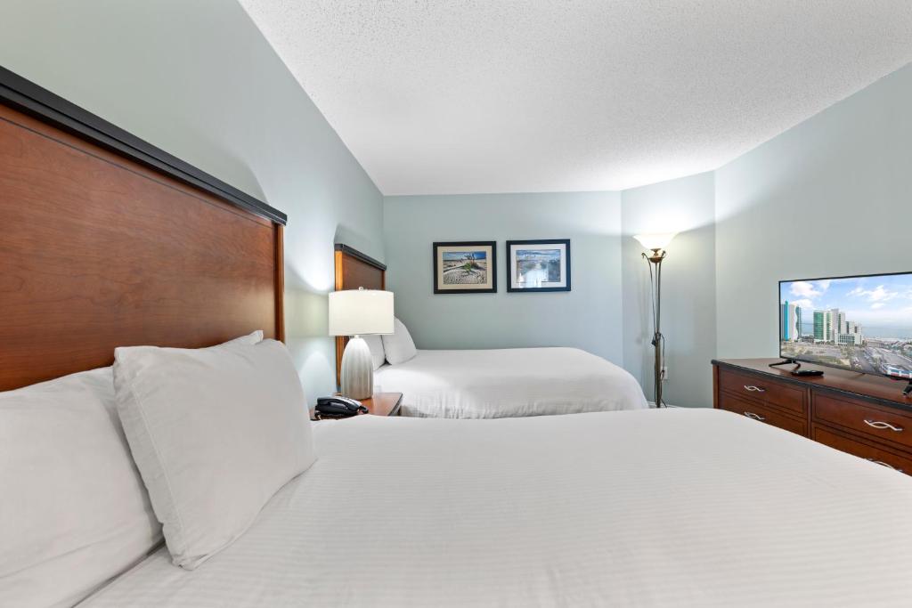 a hotel room with two beds and a flat screen tv at Sandy Beach Resort in Myrtle Beach