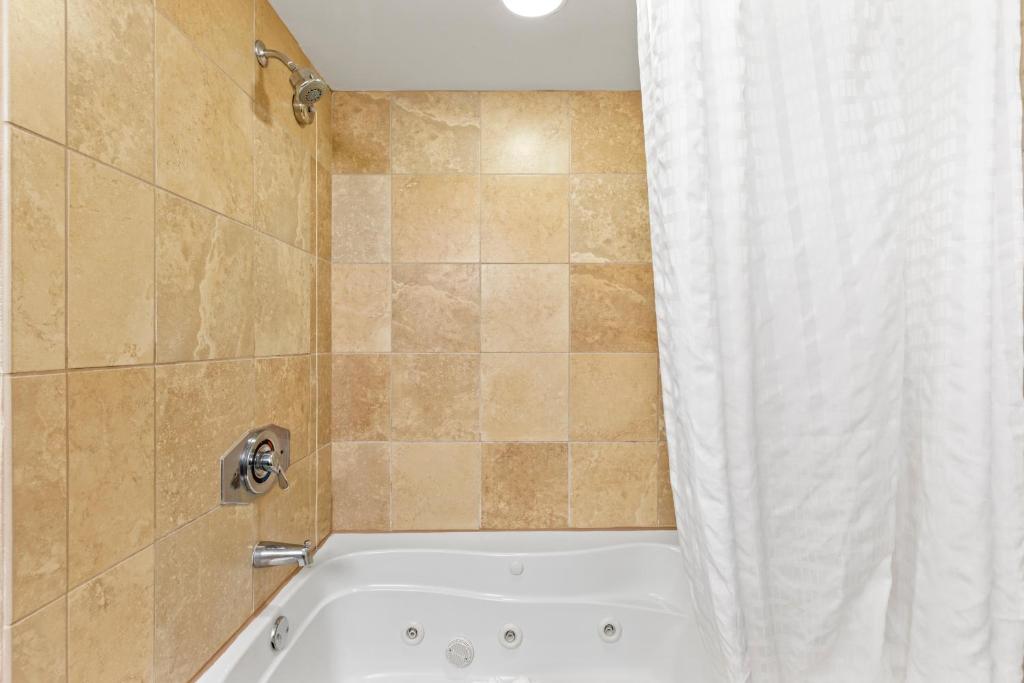 a bathroom with a bath tub with a shower curtain at Sandy Beach Resort in Myrtle Beach