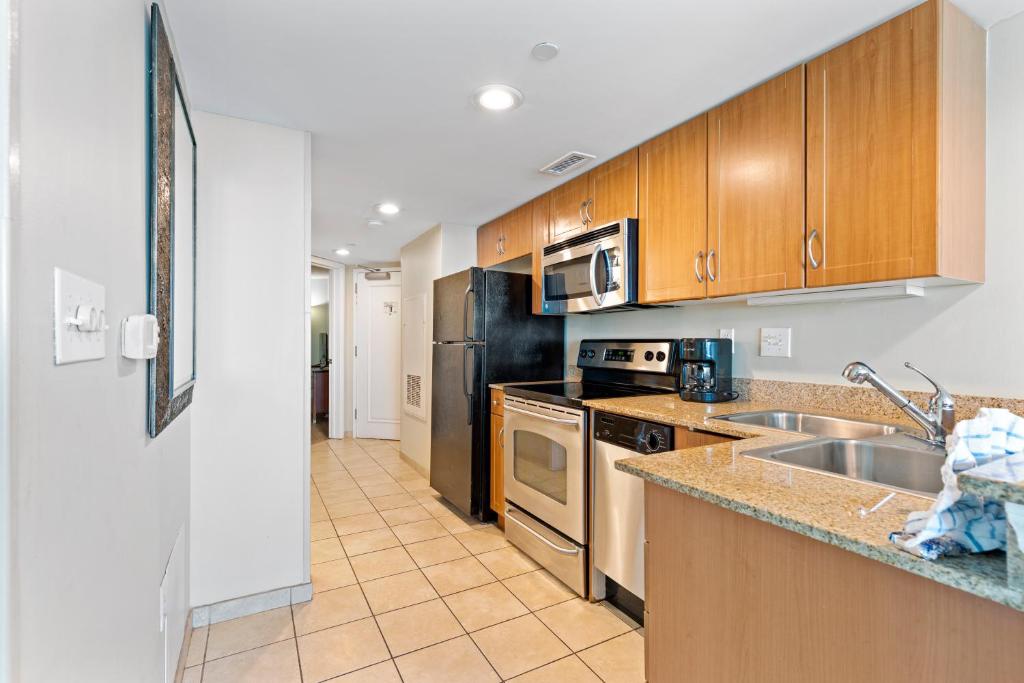 a kitchen with stainless steel appliances and wooden cabinets at Sandy Beach Resort in Myrtle Beach