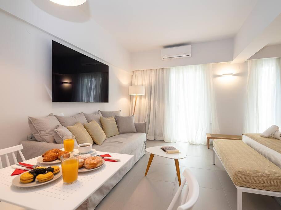 a living room with a couch and a table with food on it at Electra Luxury Apartment at the Heraklion Center in Heraklio