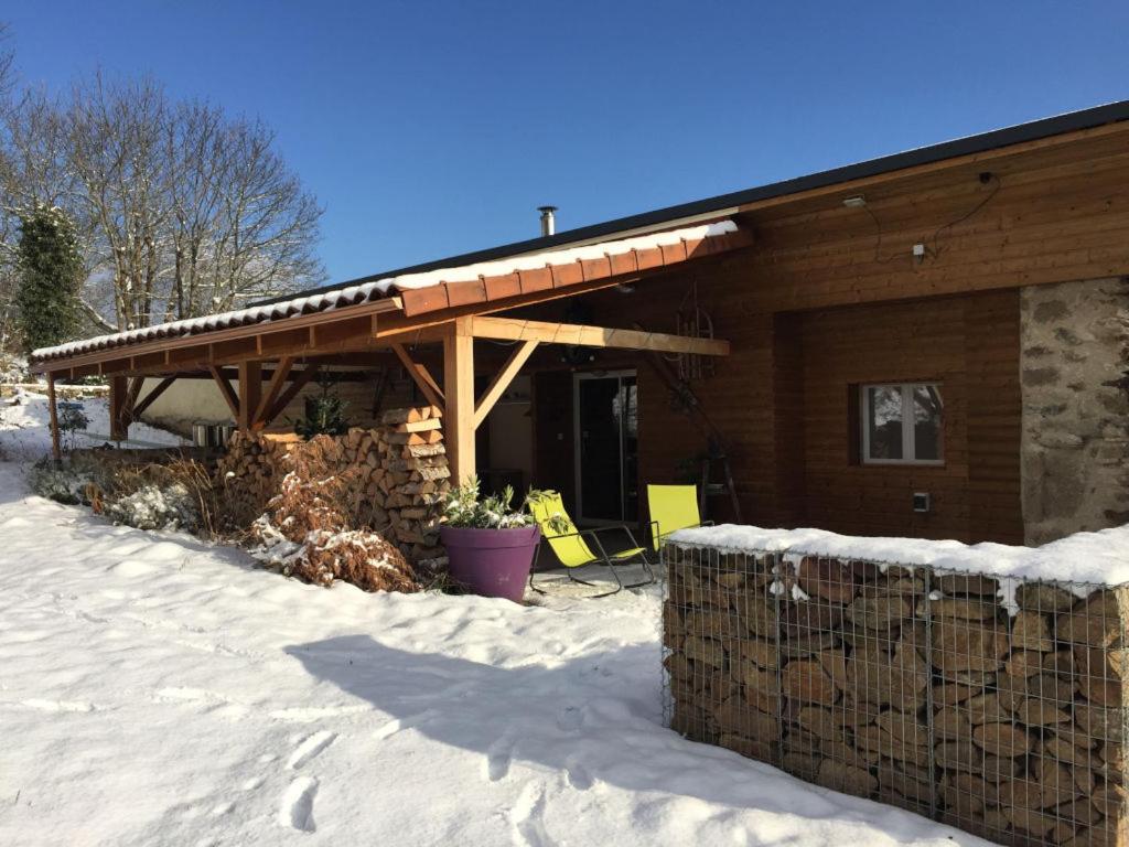 a log cabin in the snow with at Lama-Gîte-des-Puys chalet écologique à 30km des pistes, visite aux lamas Charge VE in Montaigut-le-Blanc