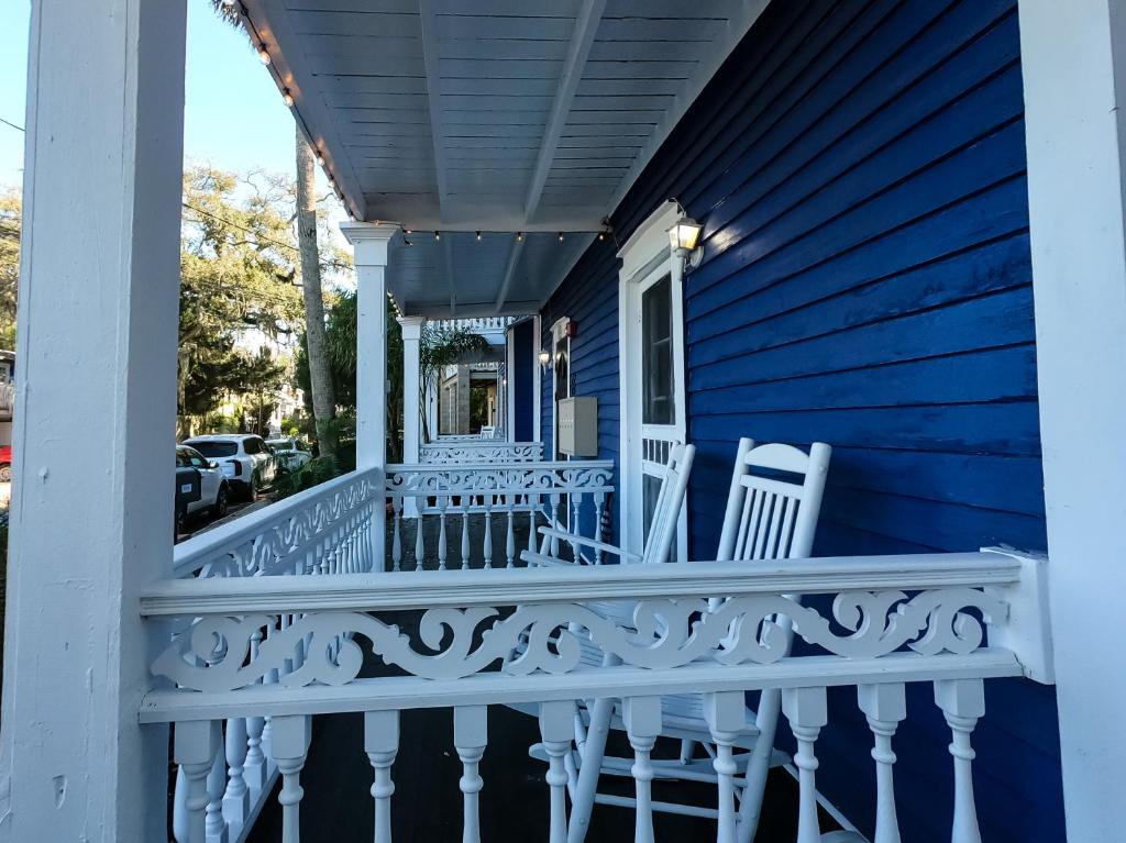 una casa blu con sedie bianche sul portico di Villa Mulvey #1 a St. Augustine