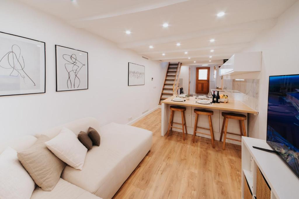 a living room with a white couch and a kitchen at Perfect family-oriented and renovated townhouse in the old Antibes in Antibes