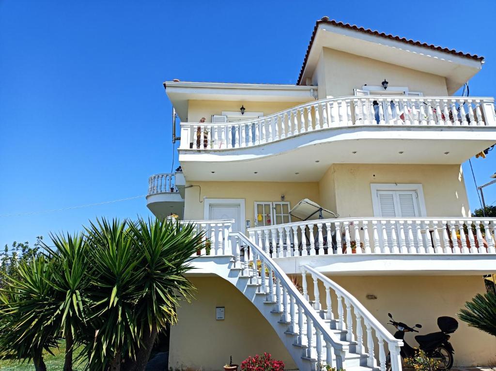 a building with white stairs and palm trees at Villa Dani in Aigio