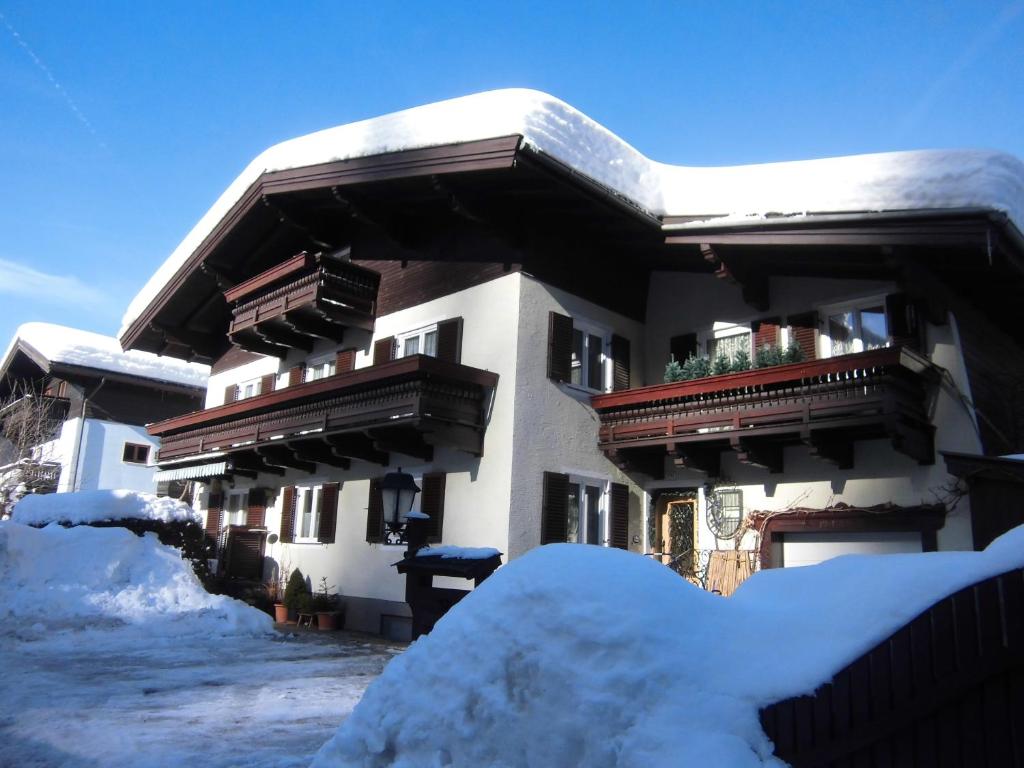 a building covered in snow with a pile of snow at Appartements Haus Schmalzl in Viehhofen