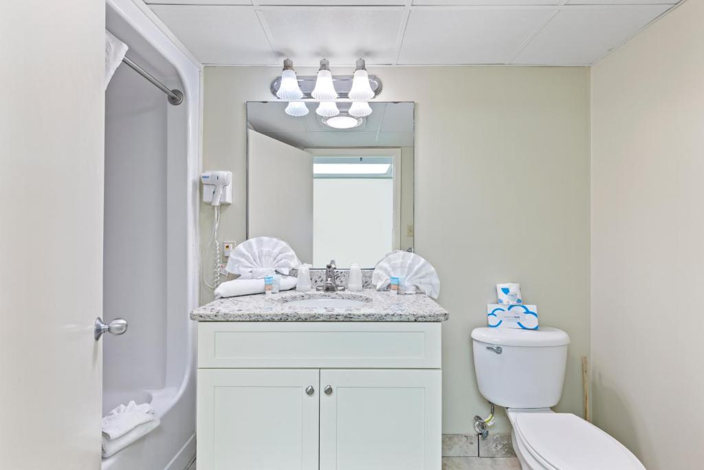a bathroom with a sink and a toilet and a mirror at Sandy Beach Resort in Myrtle Beach