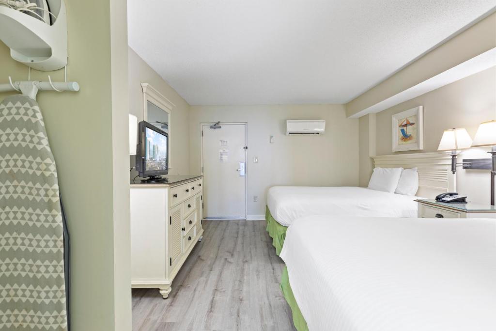 a hotel room with two beds and a television at Sandy Beach Resort in Myrtle Beach