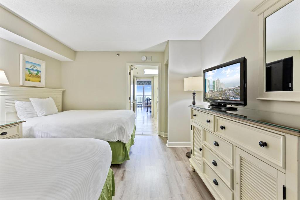 a bedroom with two beds and a flat screen tv at Sandy Beach Resort in Myrtle Beach