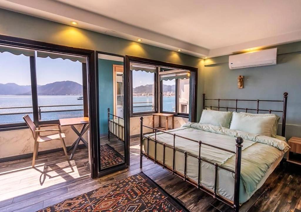 a bedroom with a bed and a view of the water at Liman Deluxe Hotel in Marmaris