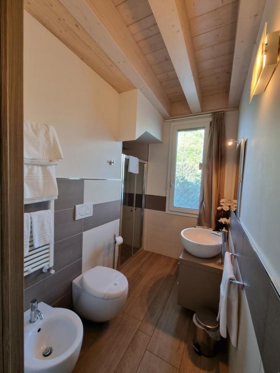 łazienka z 2 umywalkami, toaletą i oknem w obiekcie Agriturismo Dell'Orto Apartments w Weronie