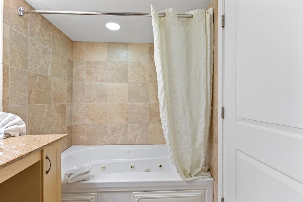 a bathroom with a tub and a shower curtain at Sandy Beach Resort in Myrtle Beach