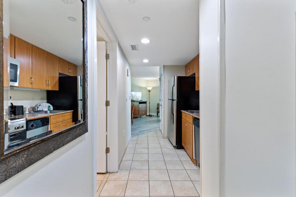 a kitchen with wooden cabinets and a tile floor at Sandy Beach Resort in Myrtle Beach