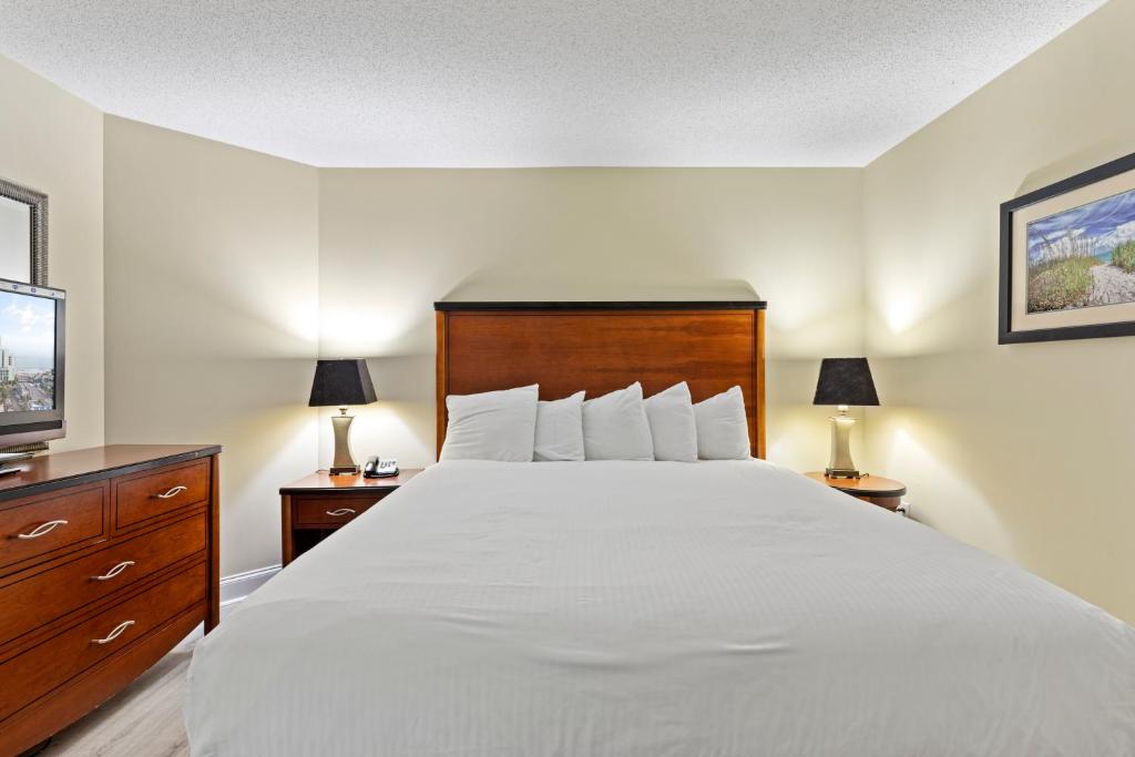 a bedroom with a large white bed and two lamps at Sandy Beach Resort in Myrtle Beach