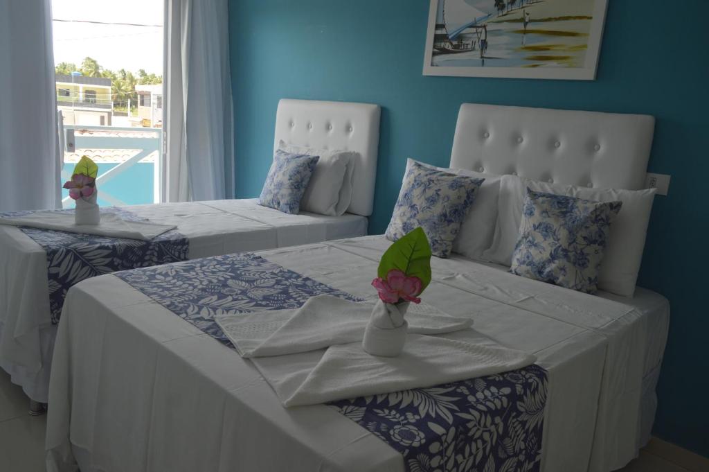 zwei Betten in einem Zimmer mit blauen Wänden in der Unterkunft Pousada Vovó Zilda Maragogi in Maragogi